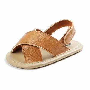Close-up of brown cross-strap baby sandals with soft non-slip soles