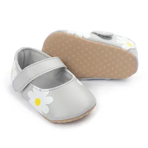 Close-up of grey baby walking shoes with white daisy patterns and non-slip soles.