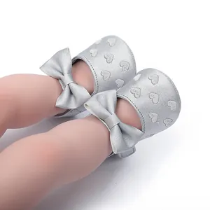 Detailansicht der silbernen Baby-Prinzessin-Schuhe mit Herzmustern und Schleifenakzent