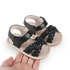 Close-up of black braided baby sandals with adjustable velcro strap