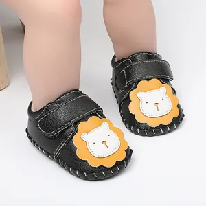 Primer plano de zapatos de bebé negros con un lindo diseño de león amarillo