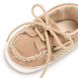 Detaillierte Makroaufnahme von braunen Wildleder-Babyschuhen mit Netzstruktur und Schnürsenkeln