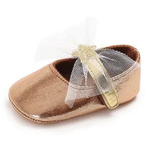 Detailaufnahme eines champagnergoldenen Baby-Prinzessin-Schuhs mit Netzschleife und Stern