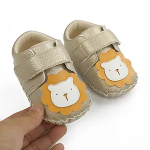 Vue détaillée de chaussures de marche pour bébé avec lion mignon et finition dorée