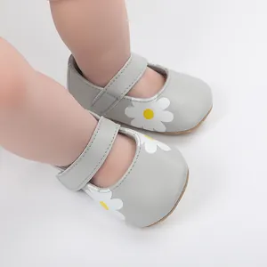 Detailed view of grey baby walking shoes with white daisy print and velcro strap