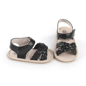 Close-up detail of black braided straps and velcro closure on newborn walking shoes