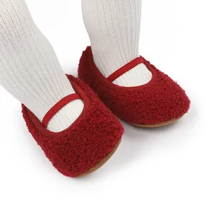 Detail van gezellige donkerrode pluizige babyschoentjes met zachte zolen voor winter