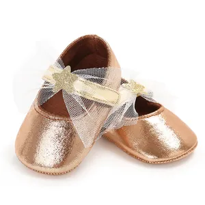 Detailansicht von roségoldenen Babyschuhen für Mädchen mit Stern und Schleife