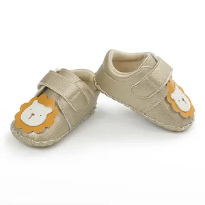 Vue détaillée de chaussures dorées pour bébé avec motif lion et semelle antidérapante.