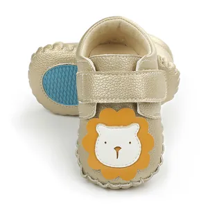 Détails de chaussures dorées pour bébé avec motif lion mignon et semelle bleue antidérapante.