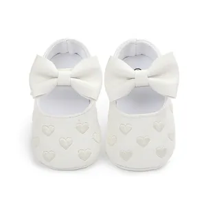 Detailed view of white soft sole baby pre-walker shoes featuring bow and heart embroidery