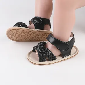 Close-up detail showing the intricate woven straps of black baby sandals for pre-walkers.