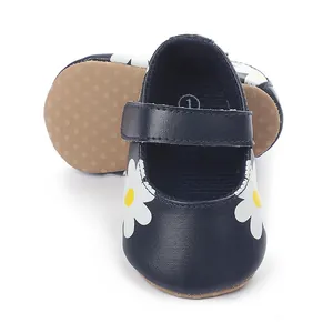 Close-up of navy blue baby walking shoes with white daisy print and Velcro strap