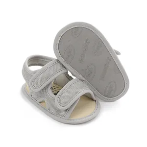 Detailopname van grijs ademend gaas en antislipzool van baby loopsandalen.