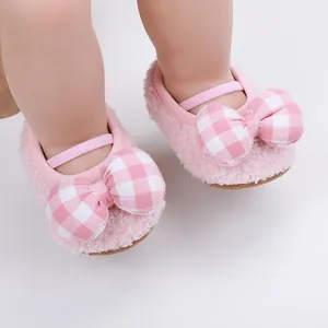 Vista dettagliata di scarpe primi passi rosa pelose per neonati con fiocchi a scacchi