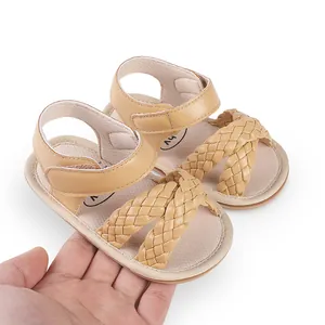 Close-up detail of beige woven baby sandals with adjustable hook-and-loop heel strap