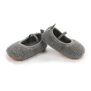 Close-up of grey fuzzy baby walking shoes with elastic strap and soft sole.