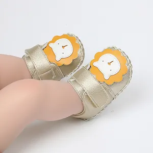 Vue détaillée de chaussures de marche pour bébé dorées avec motif de lion mignon