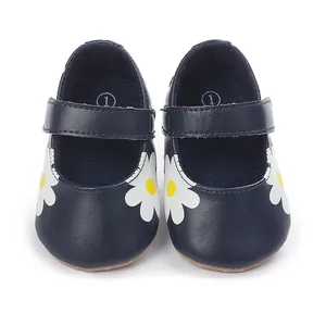 Close-up of navy blue baby walker shoes with white daisy patterns and strap