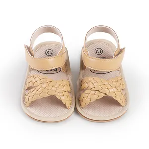 Beige baby sandals featuring braided cross-straps and a secure velcro ankle strap.