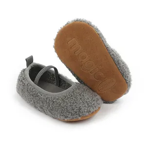 Close-up detail of grey fleece baby pre-walker shoes with soft brown soles, top view