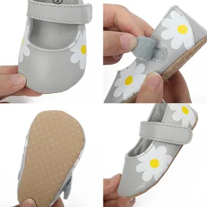 Detailed view of grey baby pre-walker shoes with white flower pattern and velcro strap