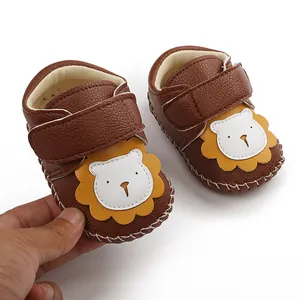 Gros plan de chaussures de marche pour bébé en similicuir marron avec un motif de lion mignon