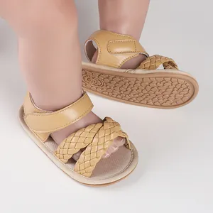 Close-up detail of beige braided baby sandals with non-slip soft rubber soles for infant.
