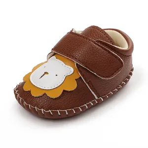 Détail de chaussure pour bébé en similicuir marron avec un motif de lion adorable.