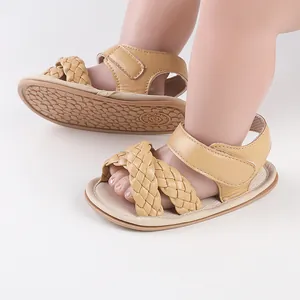 Close-up view of beige braided straps and soft soles on these newborn summer sandals.