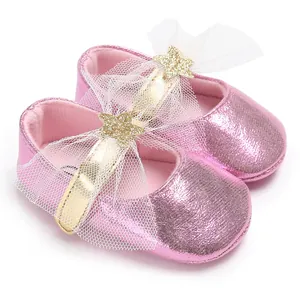 Nahaufnahme rosa glitzernder Baby-Prinzessin-Schuhe mit Goldstern und Tüllschleife