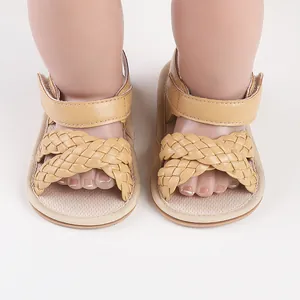 Close-up of braided cross strap baby sandals in tan color for infant walking shoes