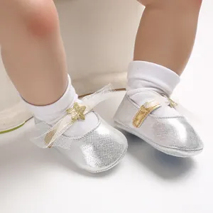 Detailansicht silberne Glitzer-Babyschuhe mit goldenem Stern und Netzschleife