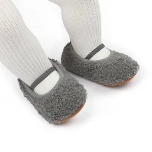 Detail van pluizige grijze babyslofjes met elastiekje op witte geribbelde panty.