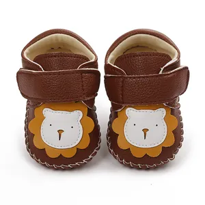 Détail de chaussures de marche pour bébé marron avec un joli motif de lion