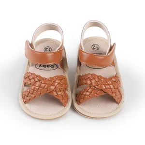 Close-up detail of brown woven leather baby girl sandals with secure velcro straps.