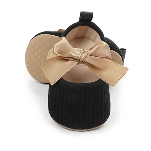 Primer plano de zapatos de princesa para bebé con un gran lazo de satén dorado decorativo