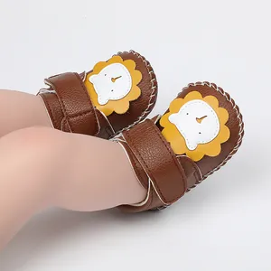 Gros plan de chaussures bébé en similicuir marron avec un joli motif de lion