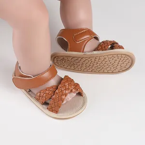 Close-up of brown braided baby sandals showing non-slip sole and hook-and-loop strap