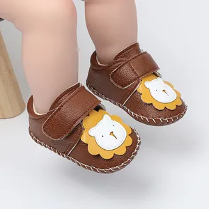 Gros plan de chaussures de bébé marron avec motif lion de dessin animé et velcro.