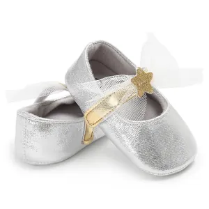 Nahaufnahme silberner PU-Babyschuhe für Mädchen mit goldenem Stern und Tüllschleife.