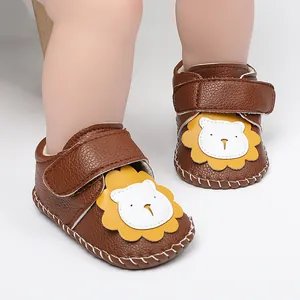 Vista detallada de zapatos de bebé en cuero marrón con un diseño de león y cierre de velcro