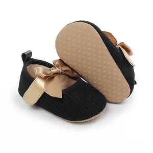 Elegantes zapatos de princesa negros para bebé con lazo dorado y suela antideslizante.