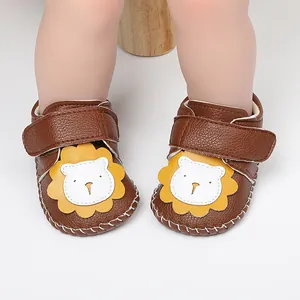 Detalle de zapatos de gateo para bebé en cuero marrón con un tierno diseño de león