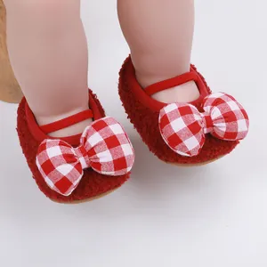 Λεπτομέρεια από κόκκινα λούτρινα βρεφικά παπούτσια με μεγάλο κόκκινο και λευκό καρό φιόγκο
