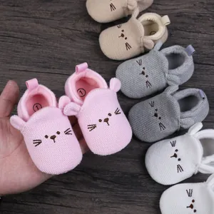 Close-up of adorable knitted baby walking shoes with cat ears and whisker details