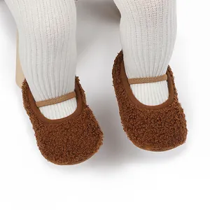 Dichtbij van bruine sherpa baby loopschoentjes met zachte zolen en elastische bandjes
