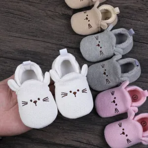 Detailed view of soft knitted baby pre-walker shoes with a cute embroidered cat face