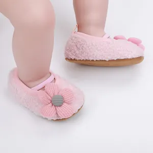 Detailansicht weicher rosa Plüsch-Babyschuhe mit einer dekorativen Blume vorne