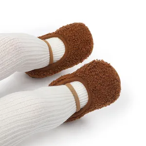 Detailopname van bruine pluizige babyschoentjes met zachte zool en elastiek.